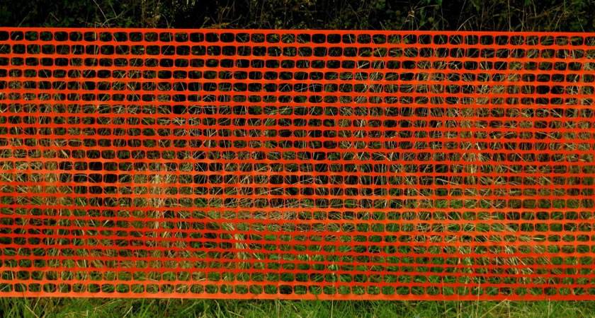 Orange plastic boundary barrier fence saves installation time and money.