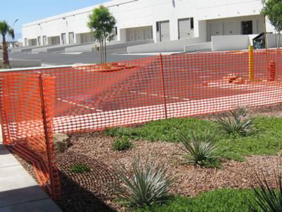 Orange plastic temporary barrier fence for plants.