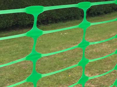 Flat oriented green barrier mesh with oval opening.